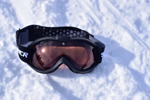 Sleek snowboard goggles resting on fresh snow, ideal for winter sports enthusiasts.