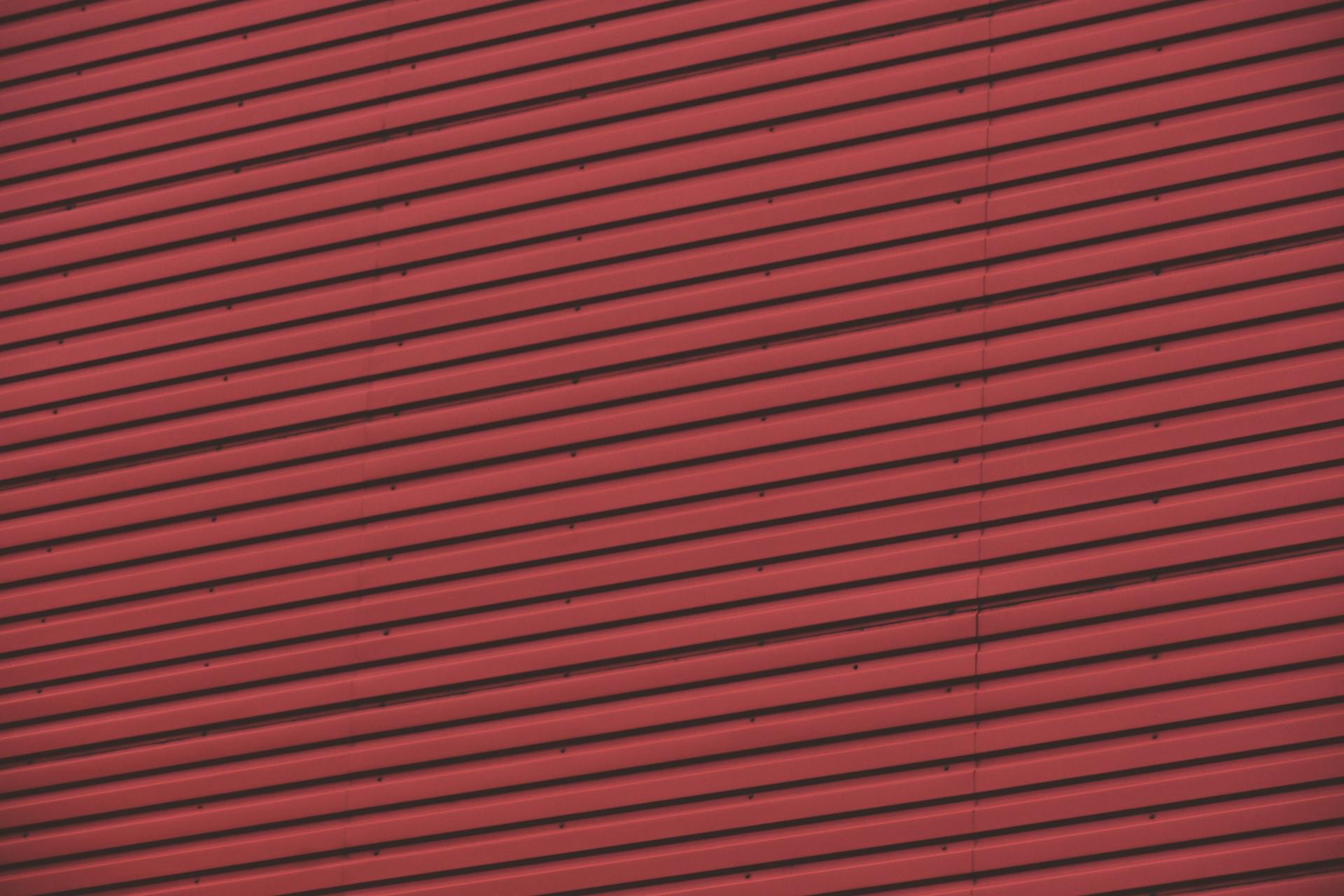 A striking abstract perspective of a red corrugated metal wall, showcasing lines and repetition.