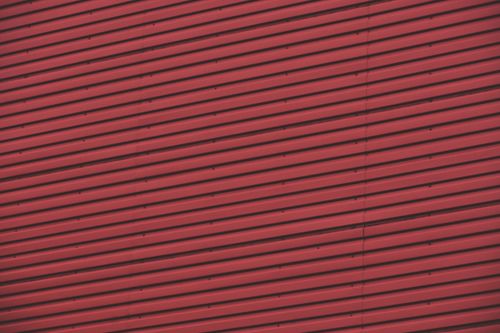Free A striking abstract perspective of a red corrugated metal wall, showcasing lines and repetition. Stock Photo