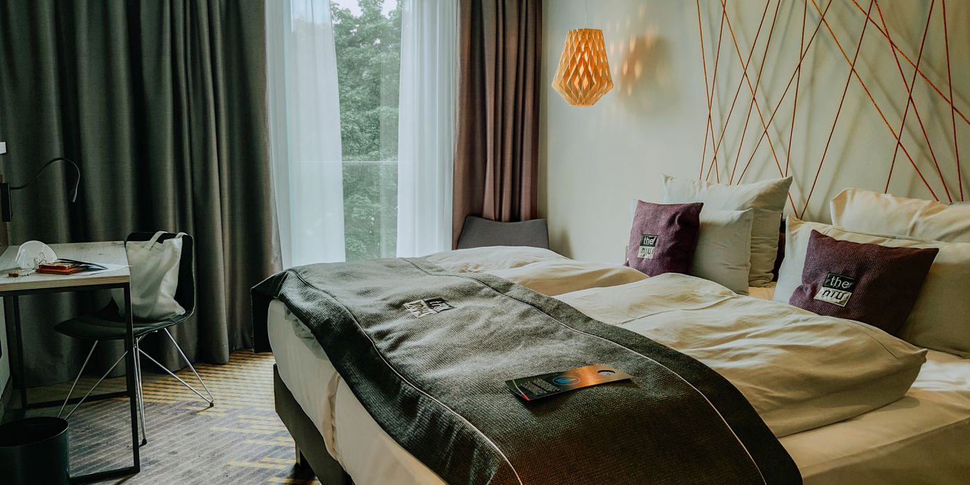 A cozy extended-stay hotel room with a bed, workspace, and warm lighting
