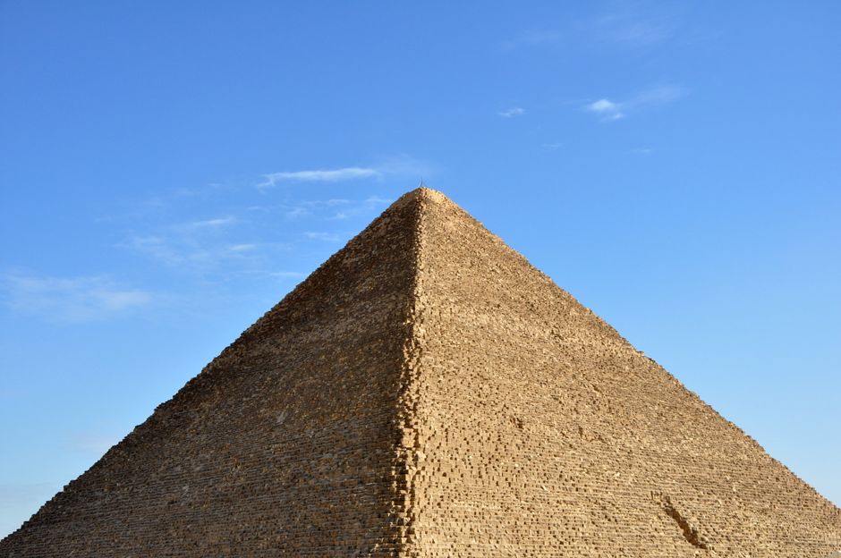 Explore the majestic side view of an ancient Egyptian pyramid under a clear blue sky.