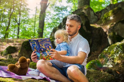 Foto Des Mannes Und Des Kindes, Das Buch Während Des Tages Liest