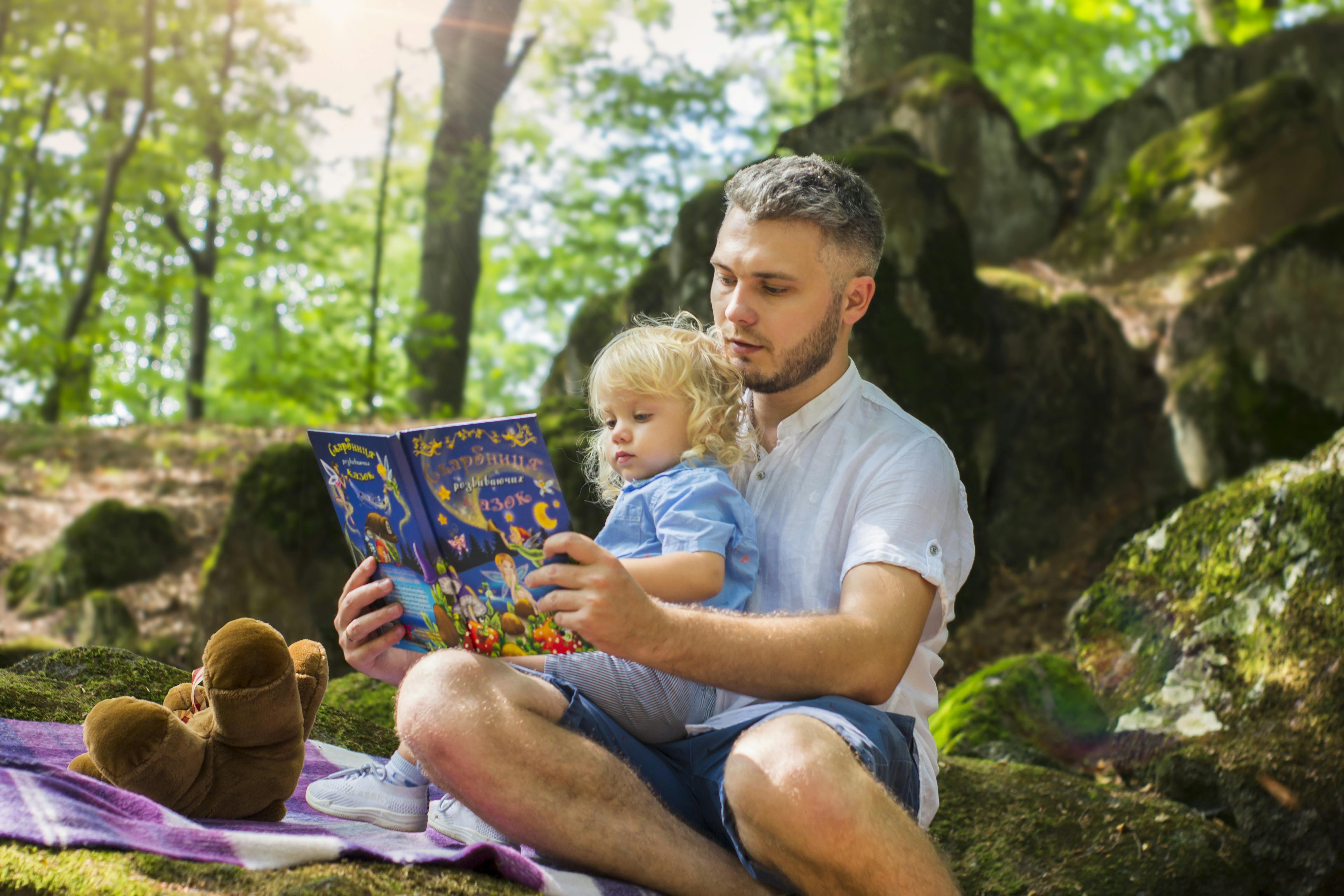 Photo Of Man And Child Reading Book During Daytime · Free Stock Photo