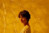 在喜怒无常的黄色灯光下，一位戴眼镜的女人艺术肖像