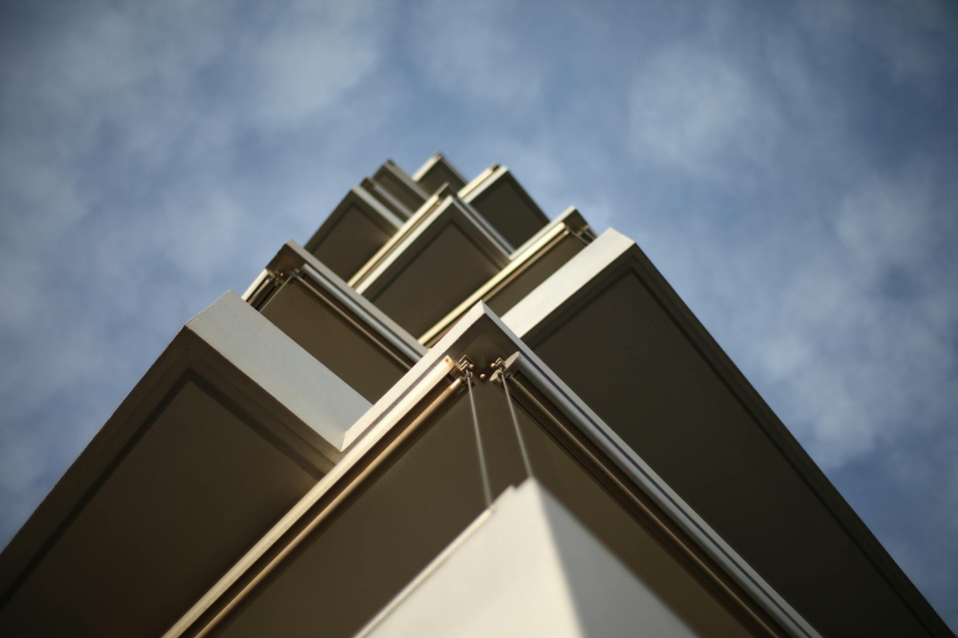 Low angle view of a modern building showcasing geometric design and clear sky.