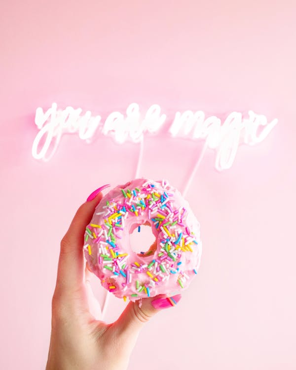 Free Donut with Sprinkles held by a Person  Stock Photo