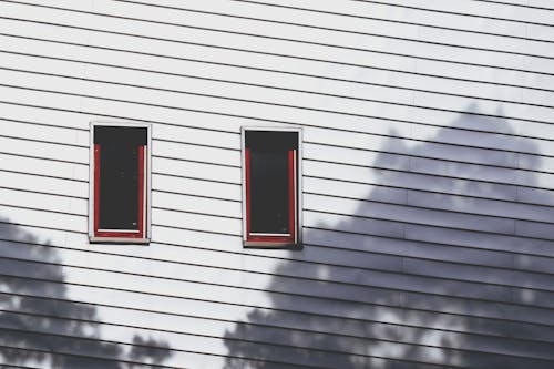 Two Windows On A Wooden Wall