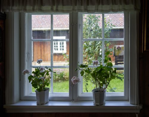 Free Charming window view with geraniums overlooking a countryside home in Lillehammer. Stock Photo