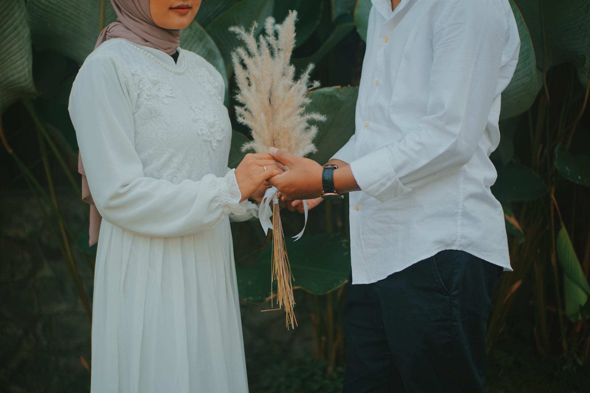 A romantic outdoor wedding scene with a couple holding hands in Jawa Timur, Indonesia.