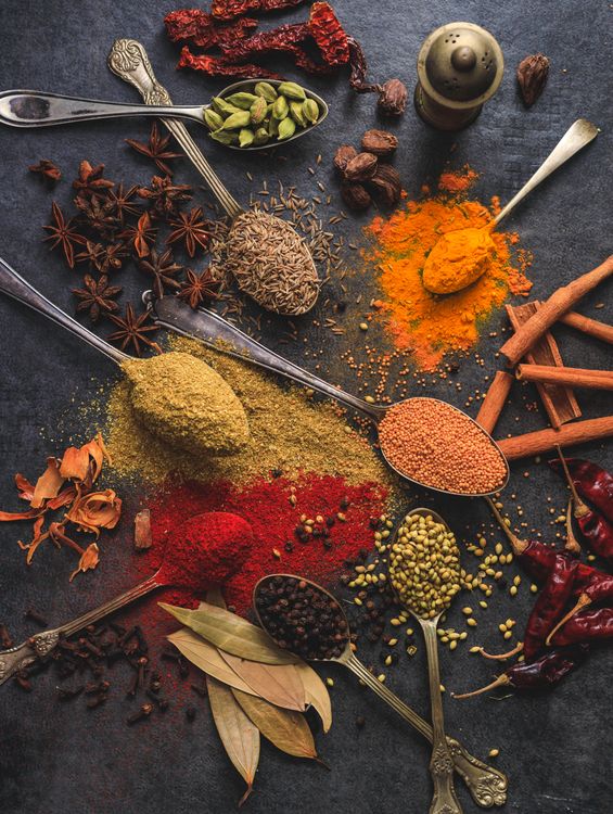 Assorted aromatic spices including turmeric, cumin, cardamom and chili