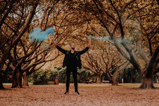 一名男子身着休闲装，在充满活力的秋季森林里手持烟雾弹