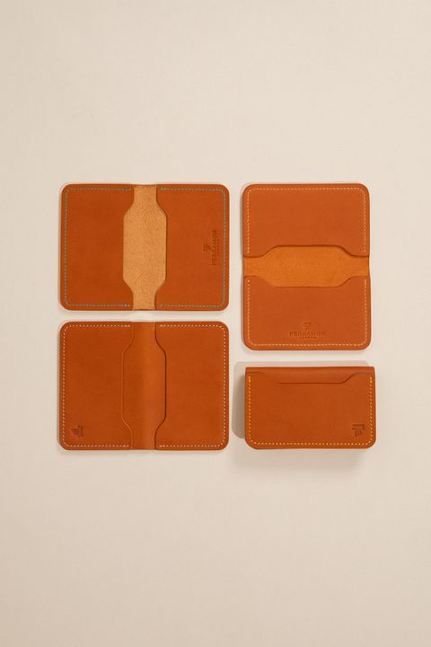 Tan leather card holders and wallets on a beige background