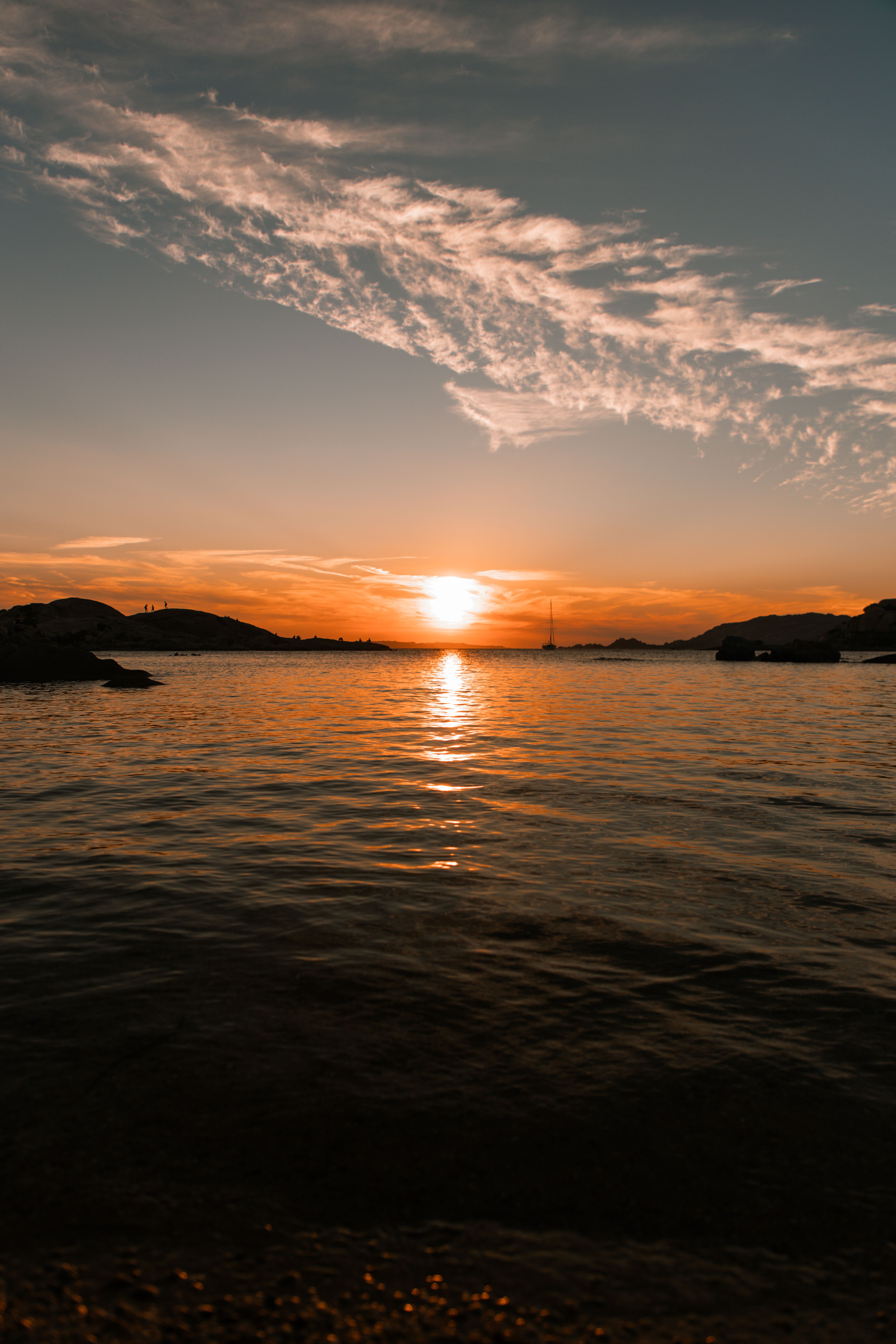 A sunset over the water with clouds and water · Free Stock Photo