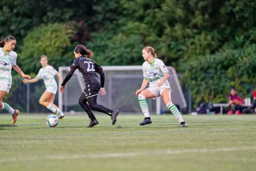 Action-packed women's soccer match showcasing skill and teamwork on an outdoor field.