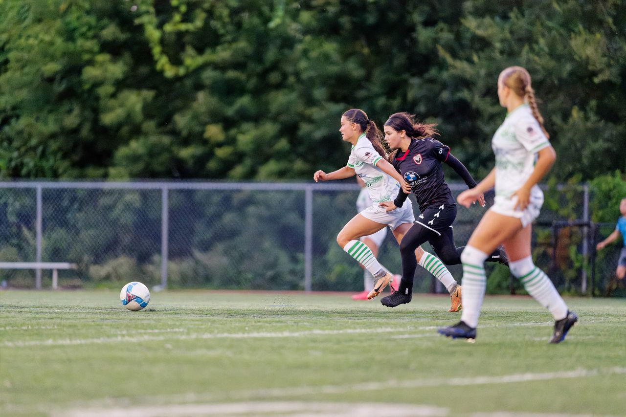 dynamic action shot of female soccer players competing on the field