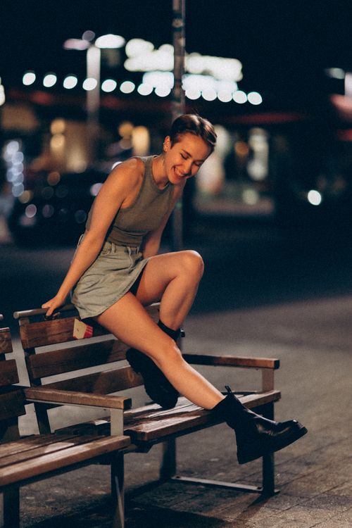Free Elegant woman in city park at night, exuding style and leisure in a vibrant urban setting. Stock Photo
