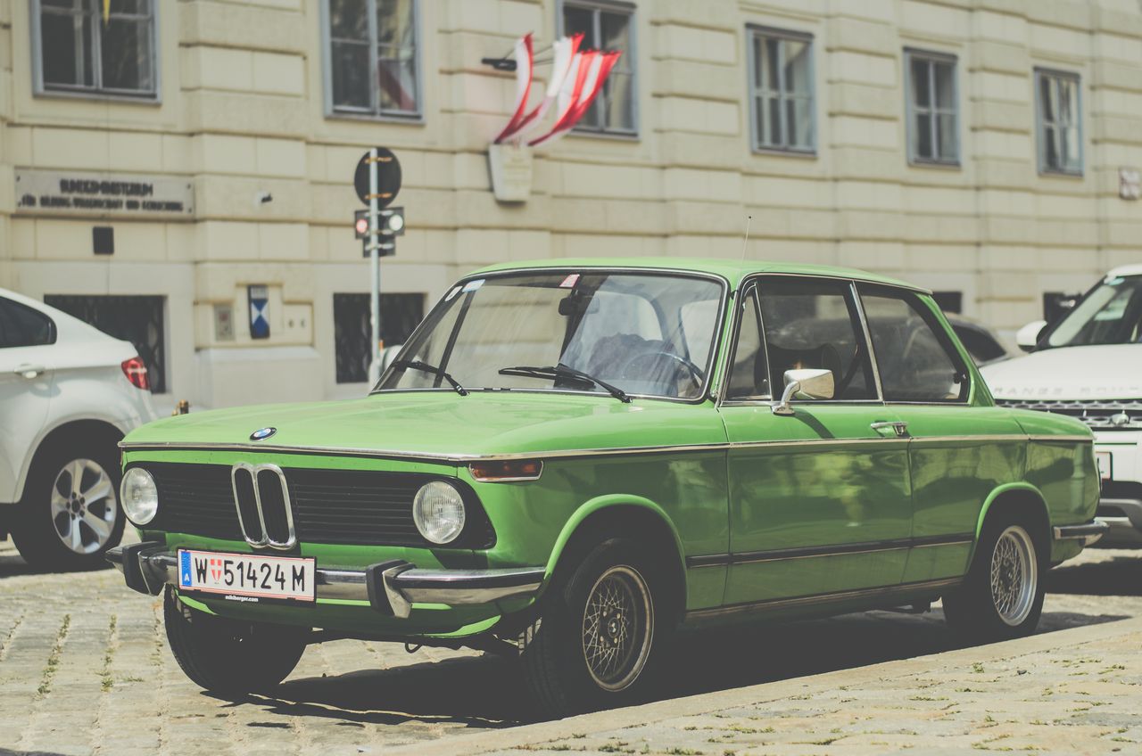 classic green bmw parked on a cobblestone street in vienna with austri