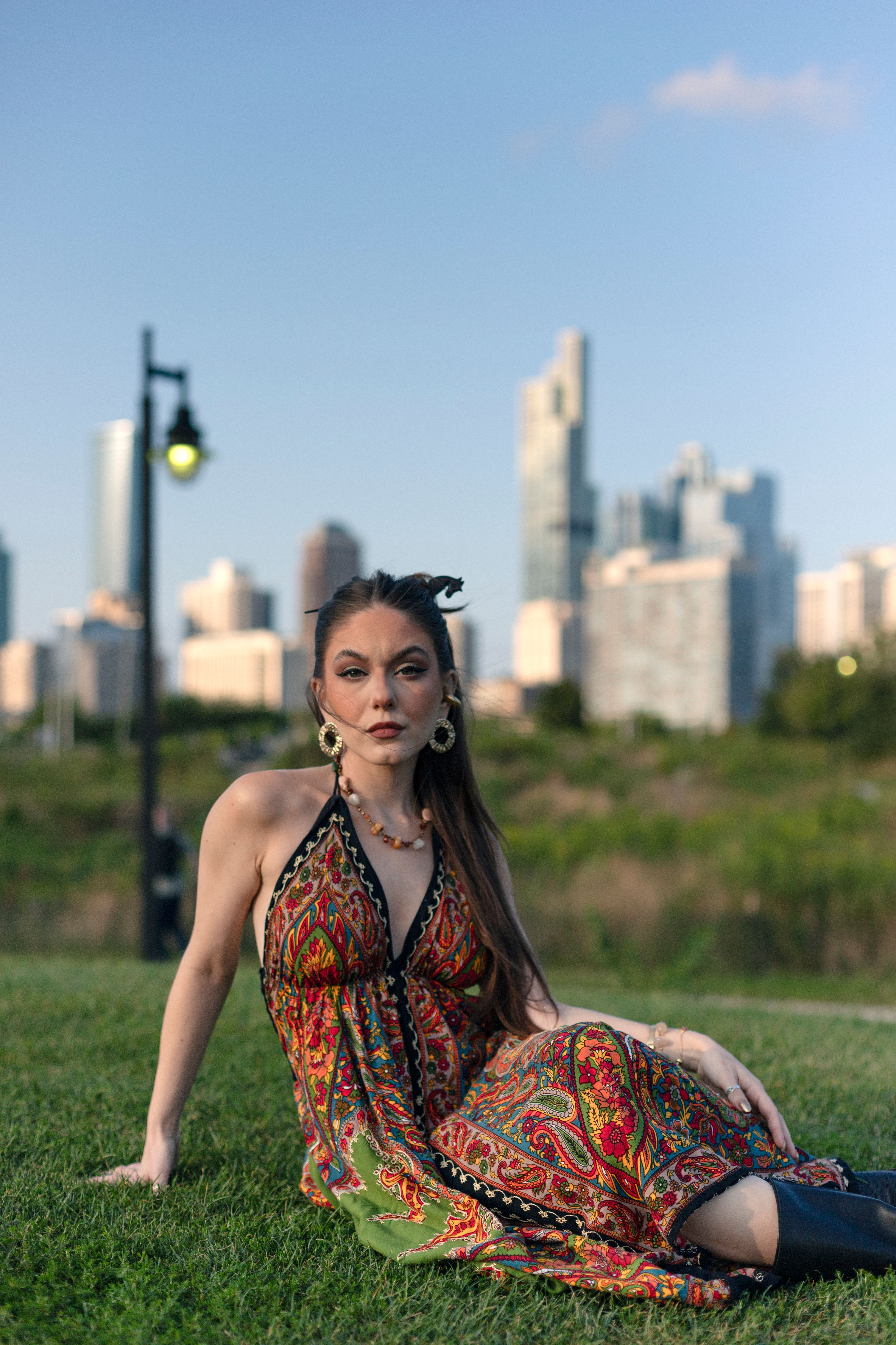 A woman in a colorful dress sitting on the grass · Free Stock Photo