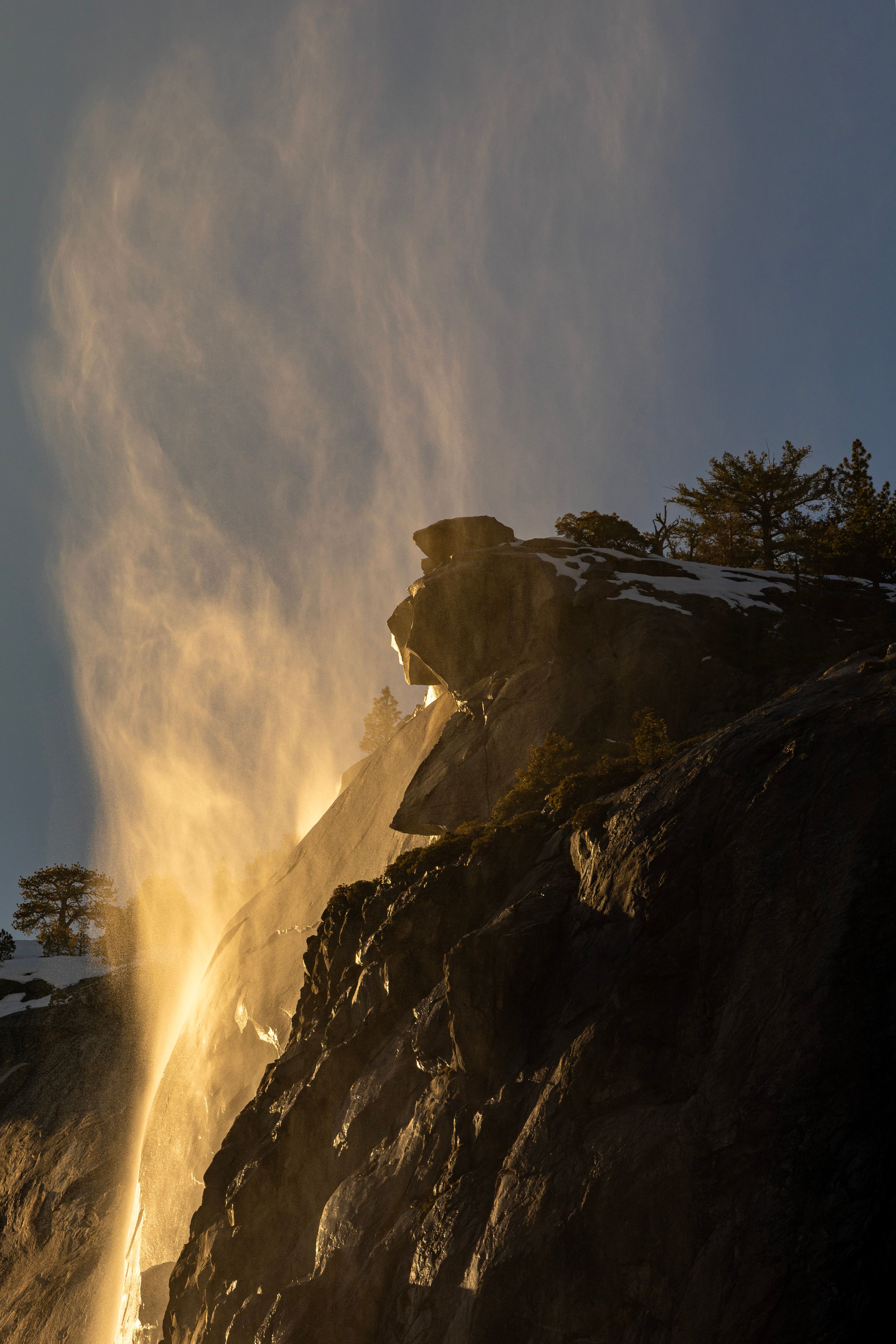 A waterfall is seen in the distance with the sun shining on it · Free ...