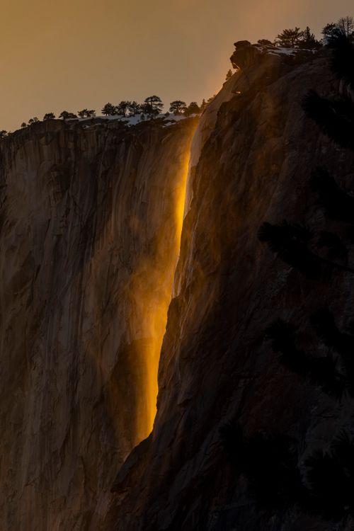 Free Dramatic view of a waterfall glowing golden at sunset in Yosemite National Park. Stock Photo