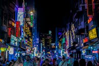 夜晚，繁忙的城市街道霓虹灯明亮，人群拥挤