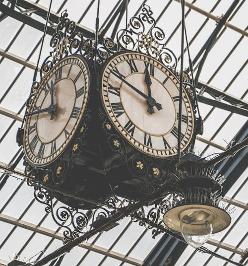 Two Round Brown Wooden Analog Clocks