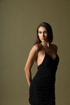 Stylish studio portrait of a young woman in an elegant black dress, exuding sophistication.