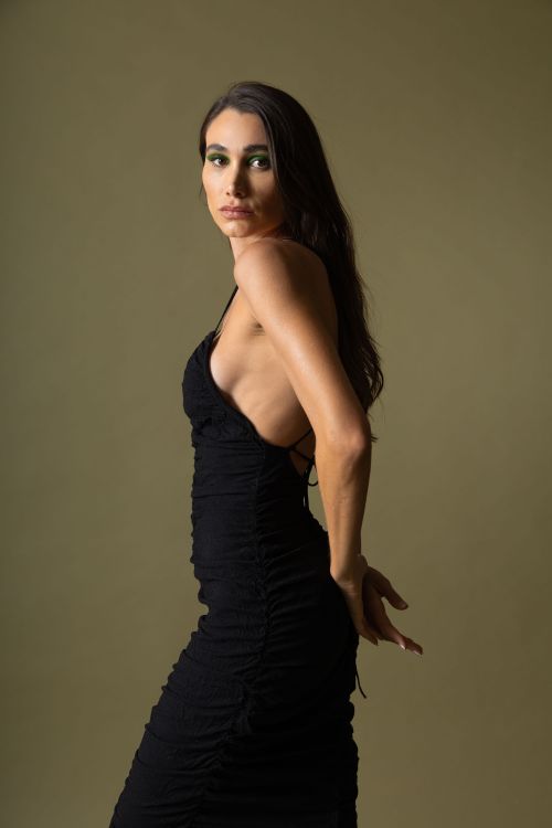 Free Stylish portrait of a woman in a black dress against a neutral background. Stock Photo