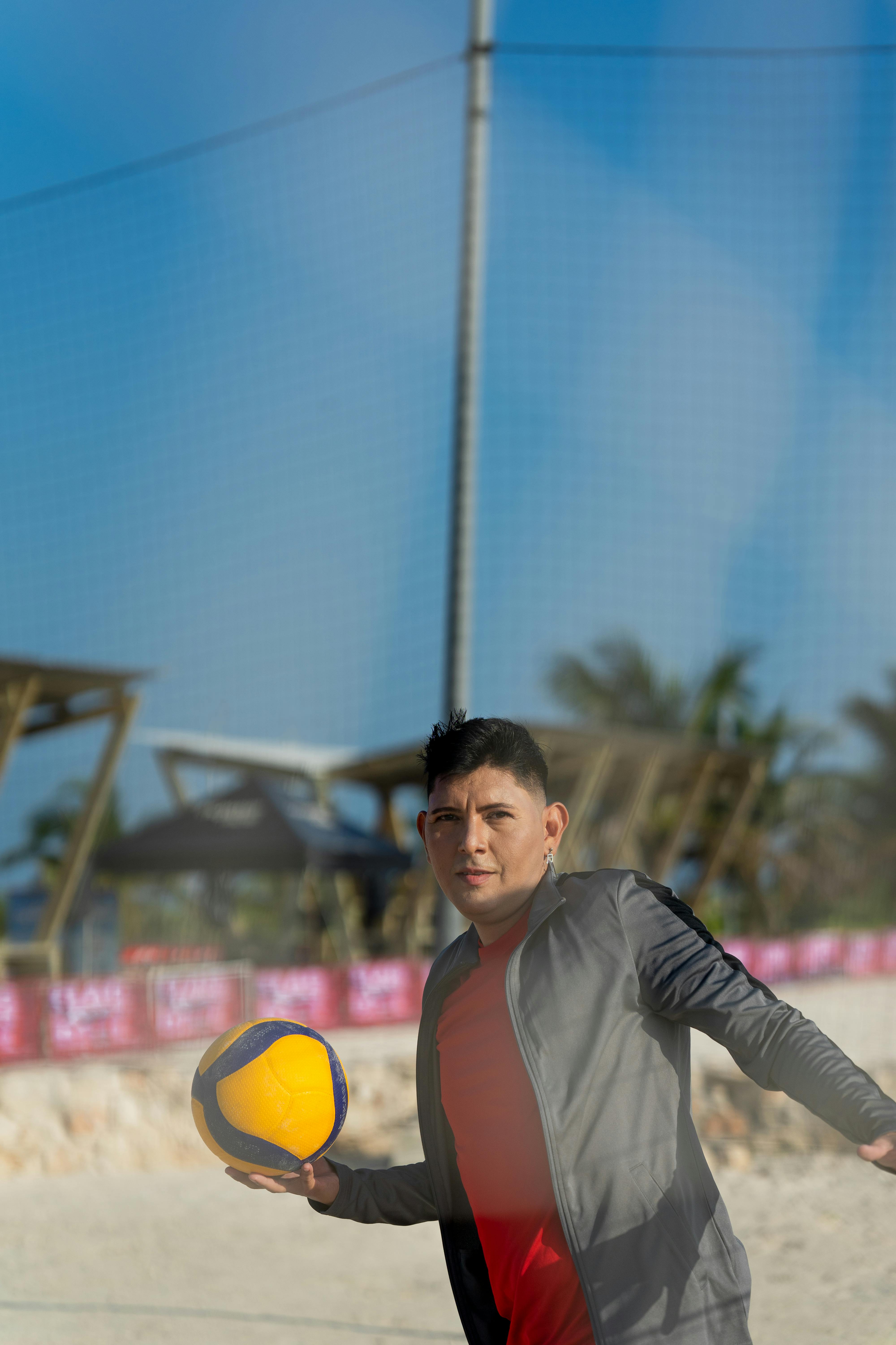 a man in red shirt and black shorts holding a ball