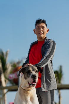 A young man in sportswear spends a sunny day on the beach with his dog in Progreso, Mexico.