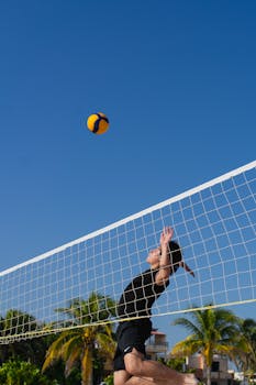 Beach volleyball action shot in Progreso, Yucatan, capturing summer sports fun under clear blue skies.