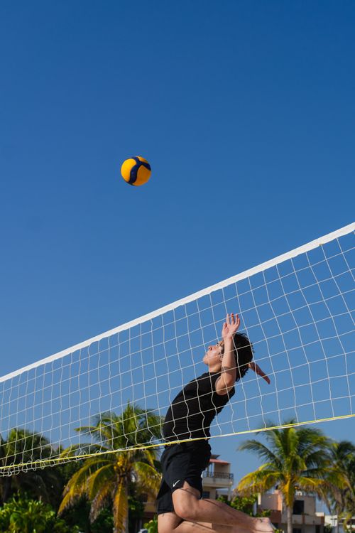 Free Beach volleyball action shot in Progreso, Yucatan, capturing summer sports fun under clear blue skies. Stock Photo