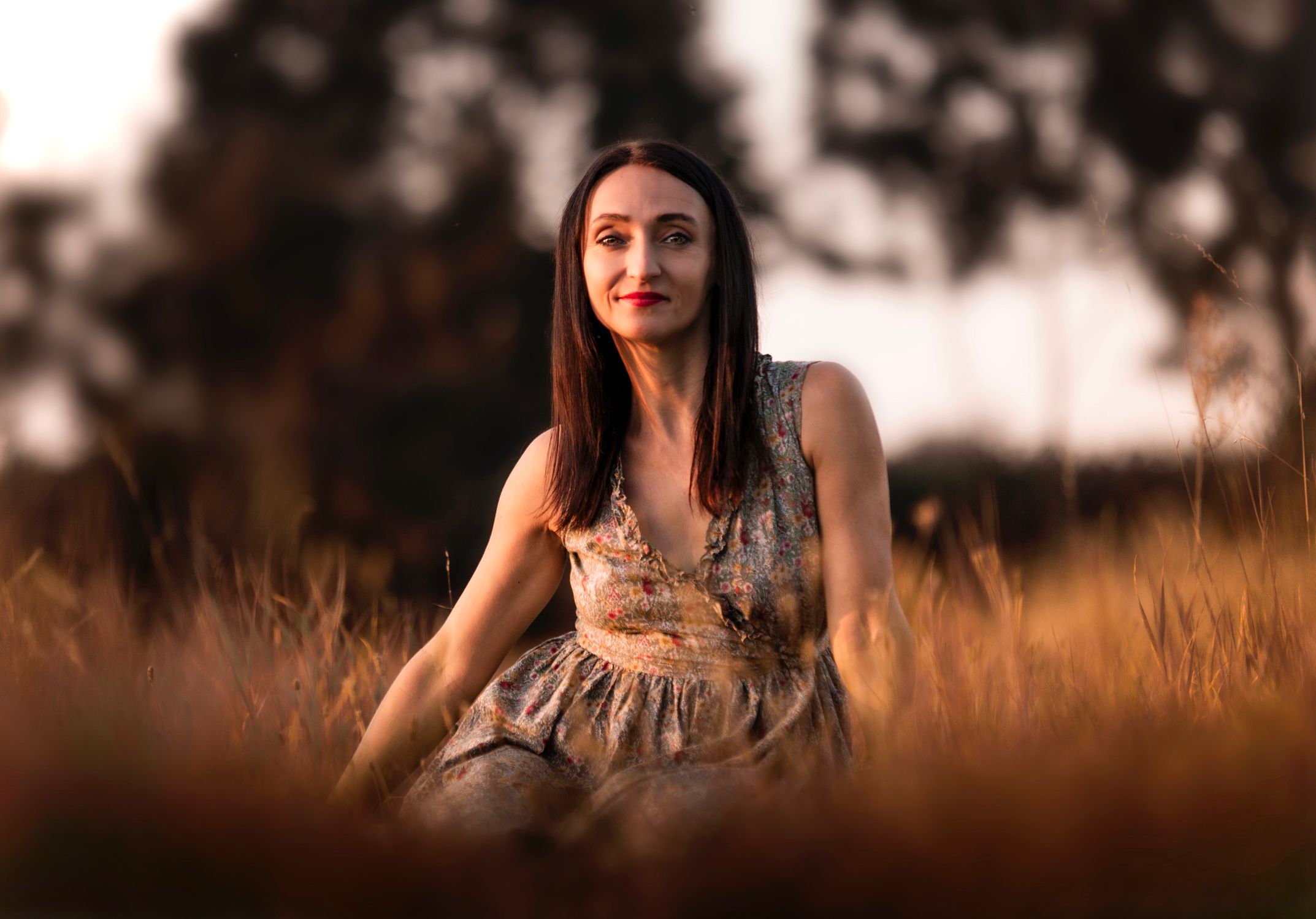 A woman sitting in a field with long hair · Free Stock Photo