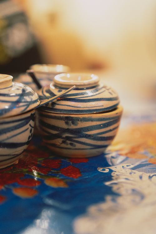 Free Traditional ceramic bowls with lids on a vibrant table in Ho Chi Minh City, Vietnam. Stock Photo
