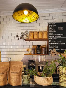A stylish coffee shop interior showcasing espresso bar and merchandise display under warm lighting.