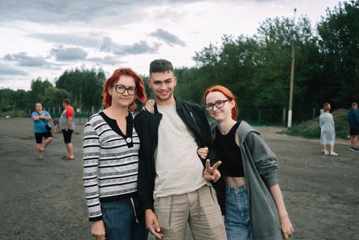 A cheerful group of adults and teenagers posing outdoors in Belarus during summer.