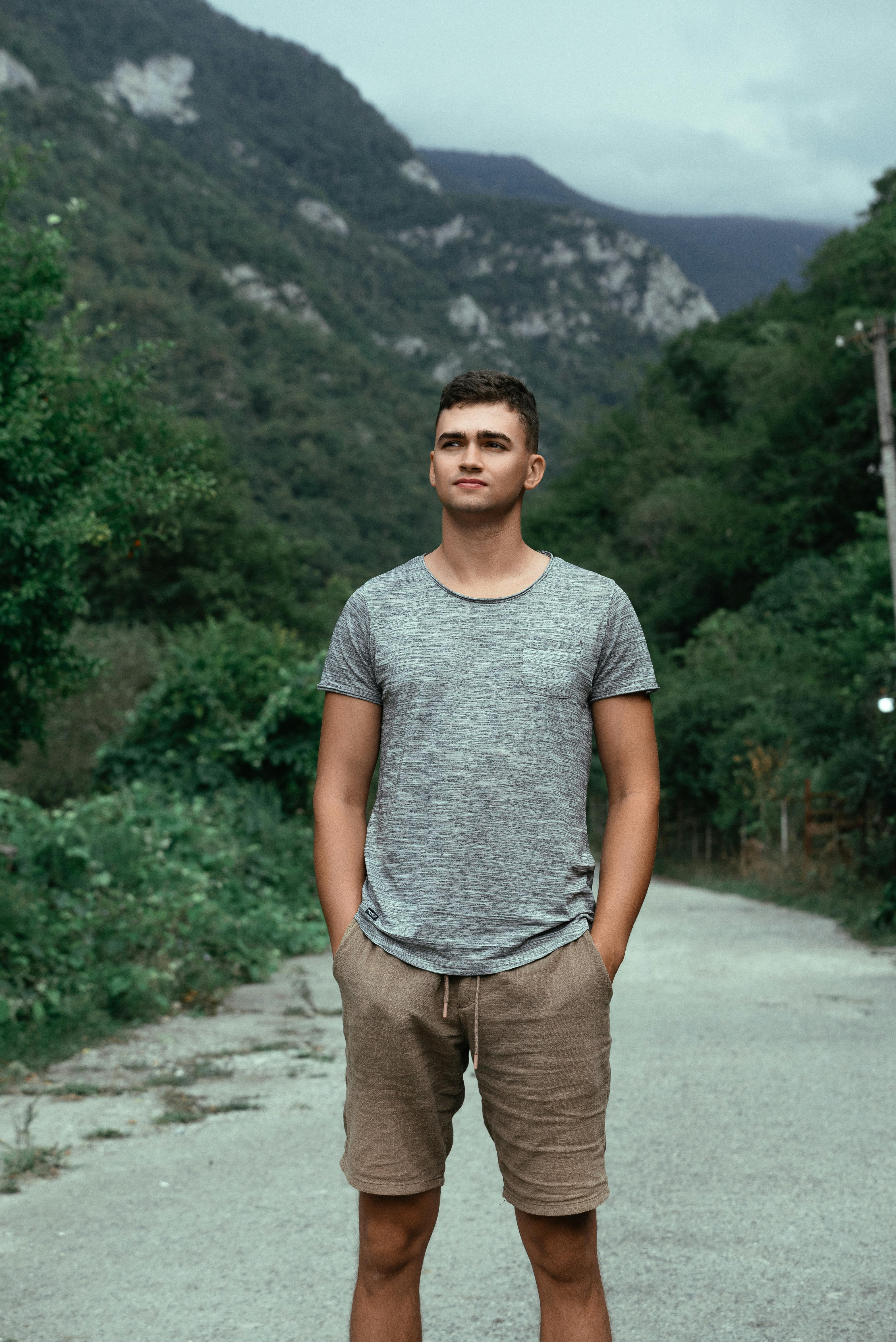 a man standing on a road in front of mountains