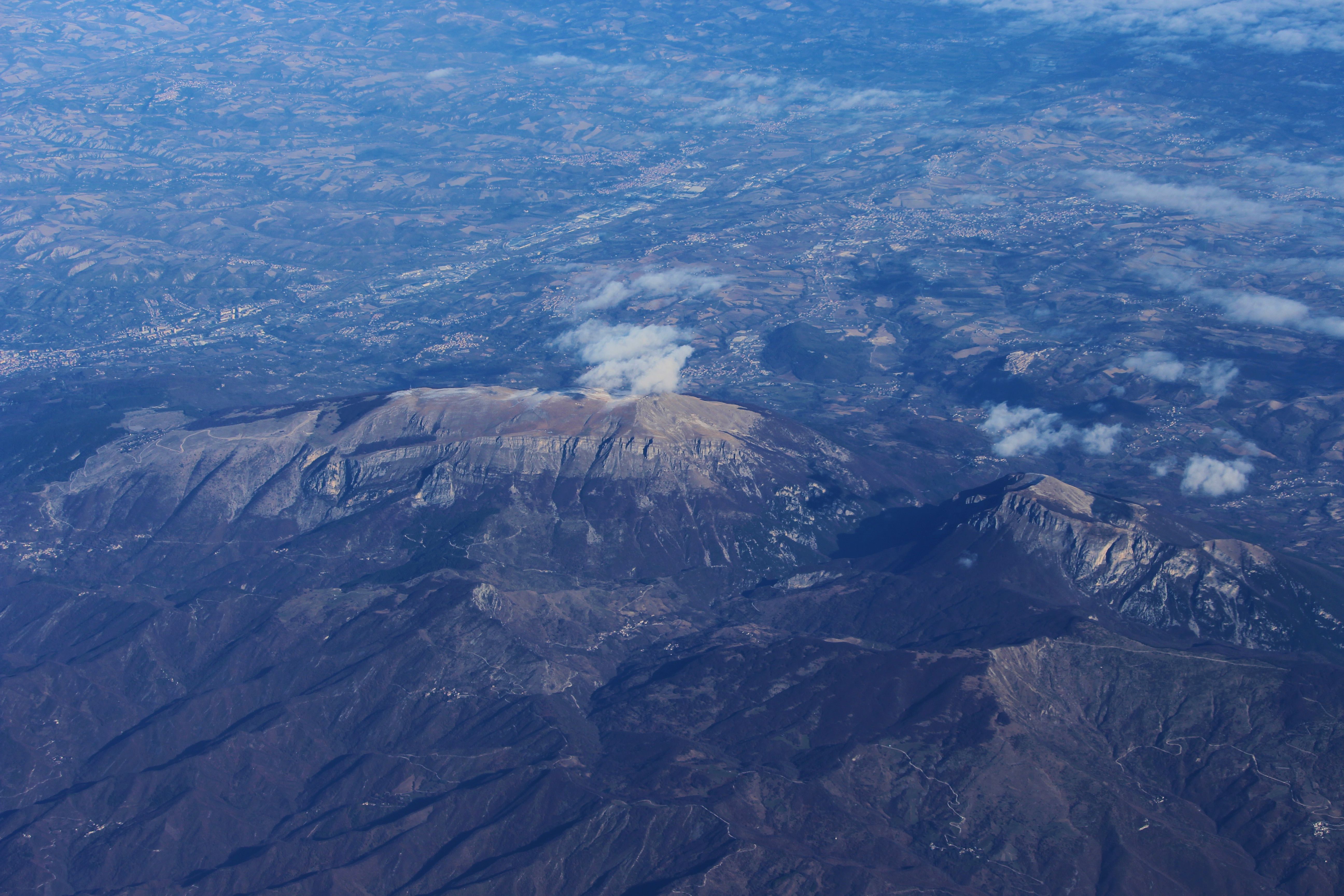 An aerial view of a mountain range with clouds · Free Stock Photo