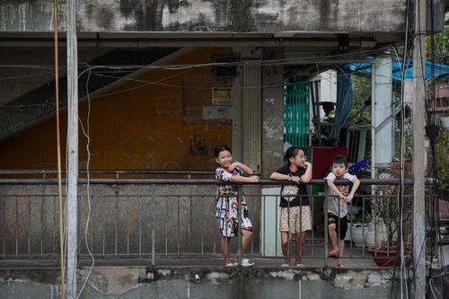 Free Children enjoying their time on a balcony in Ho Chi Minh City's urban setting. Stock Photo