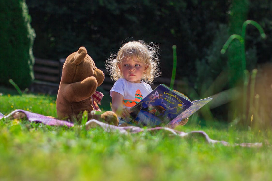 Free Girl Sitting Beside A Teddy Bear Stock Photo