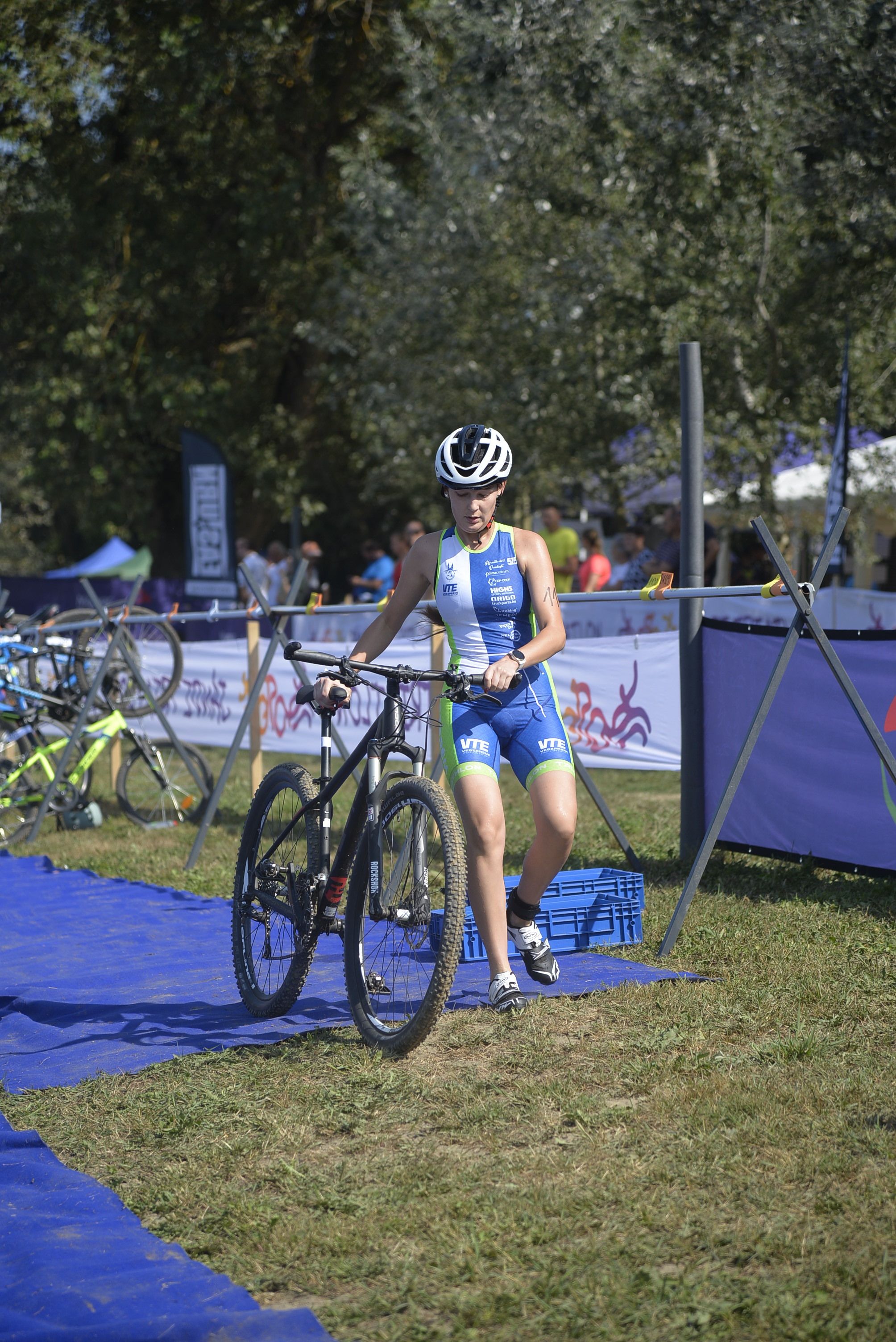 Triathlete transitions to biking at outdoor event, showcasing athletic endurance and competition.