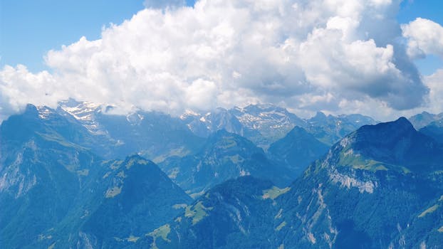 Stunning landscape of Alpine mountains with dramatic clouds, perfect for outdoor and travel themes.