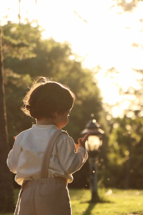 Free Charming child enjoying a sunny day in a lush park setting, embodying innocence and joy. Stock Photo