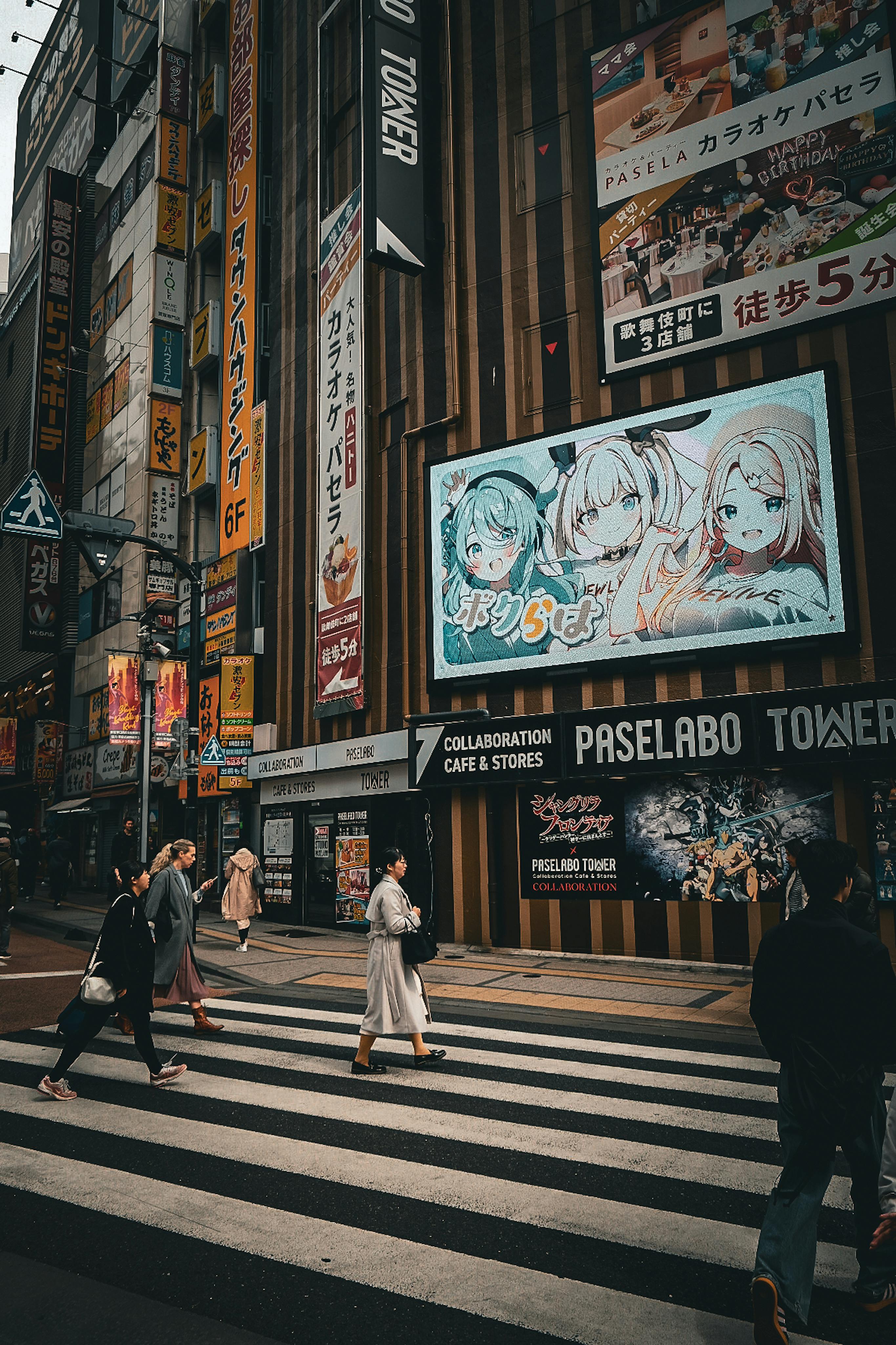 People crossing the street in front of a large billboard