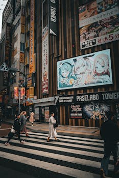 People crossing a vibrant Tokyo street lined with colorful advertisements.