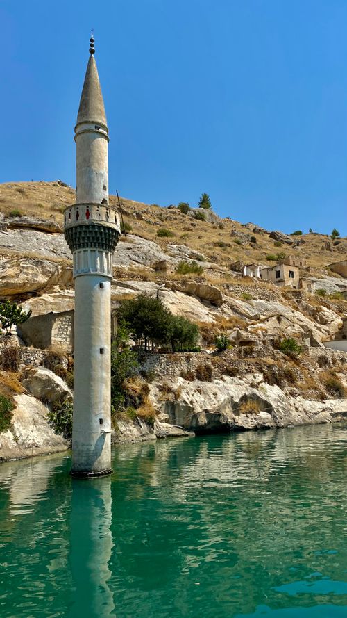 Free A historic minaret partially submerged in clear turquoise waters, highlighting unique architecture. Stock Photo