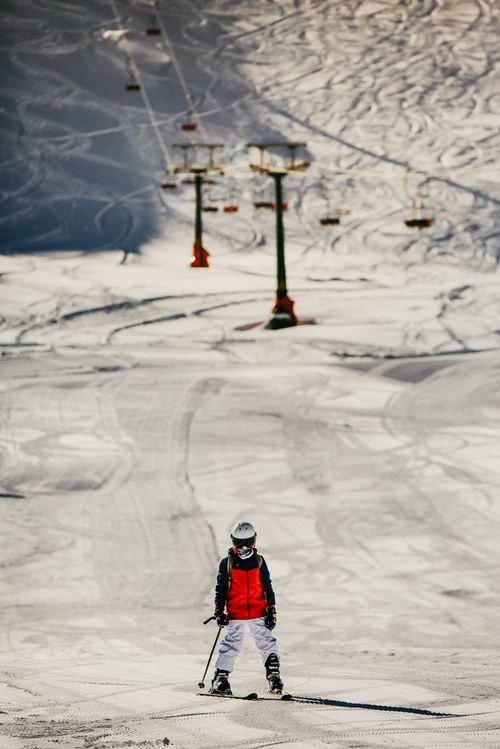 Free Young skier enjoying a sunny day on snow-covered slopes in Antalya, Türkiye with lifts in the background. Stock Photo