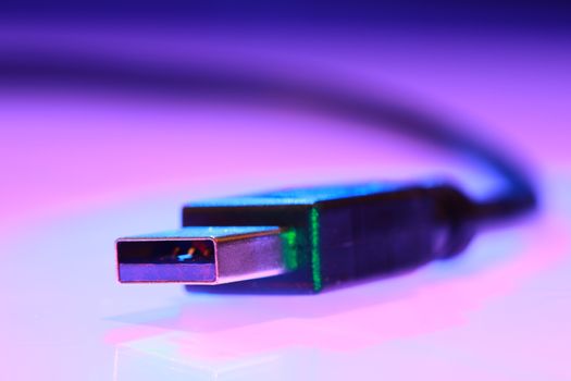 Close-up of a USB cable against a purple gradient background