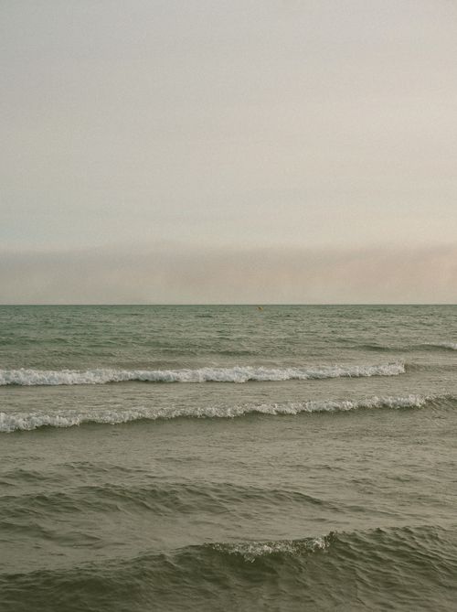 Free Calm sea waves gently crashing under a tranquil sky at sunset. Stock Photo