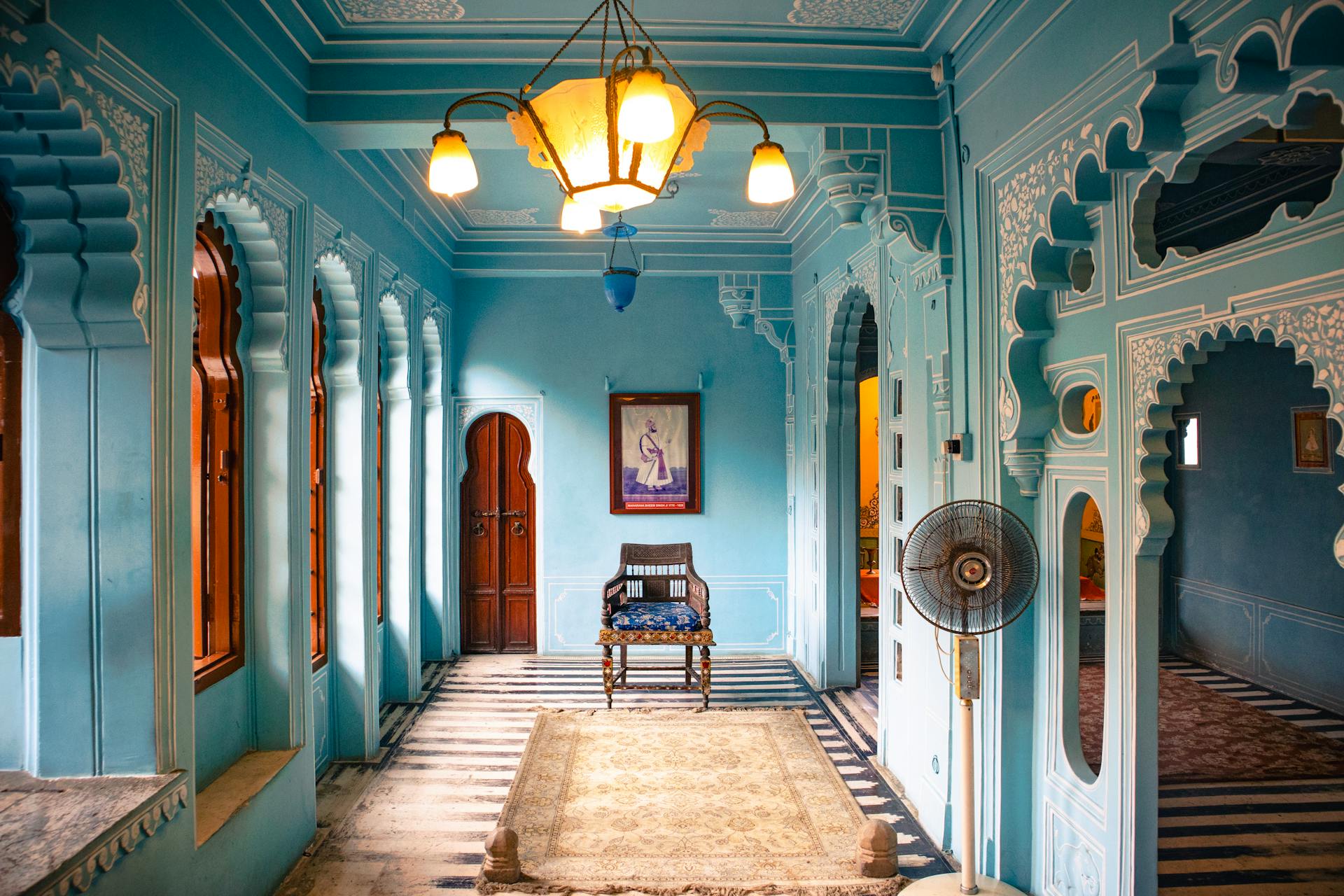 A room with blue walls and a ceiling fan